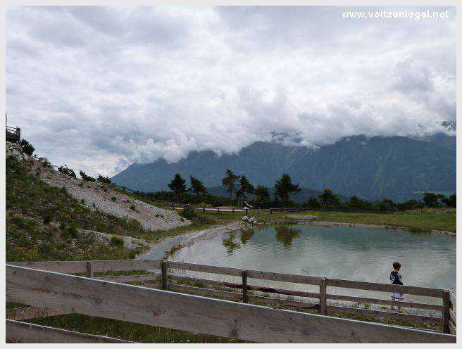 Vue panoramique du lac de Mieming, reflétant les Alpes du Tyrol sous un ciel ensoleillé