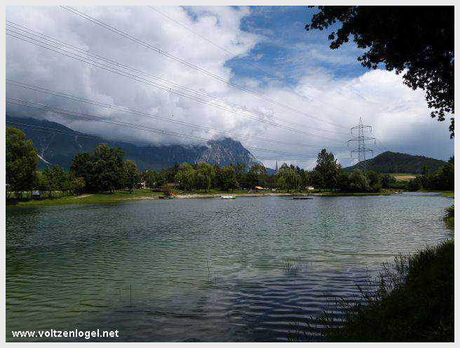 Vue panoramique du lac de Mieming, reflétant les Alpes du Tyrol sous un ciel ensoleillé