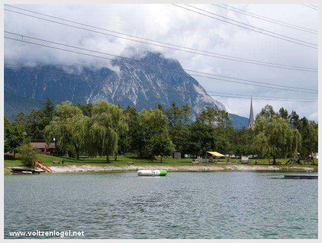 Vue panoramique du lac de Mieming, reflétant les Alpes du Tyrol sous un ciel ensoleillé