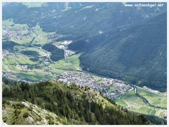 Panorama hivernal de Schlick2000, avec des skieurs dévalant les pistes enneigées des Alpes autrichiennes