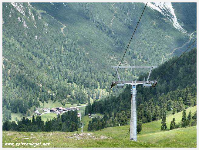 Panorama hivernal de Schlick2000, avec des skieurs dévalant les pistes enneigées des Alpes autrichiennes